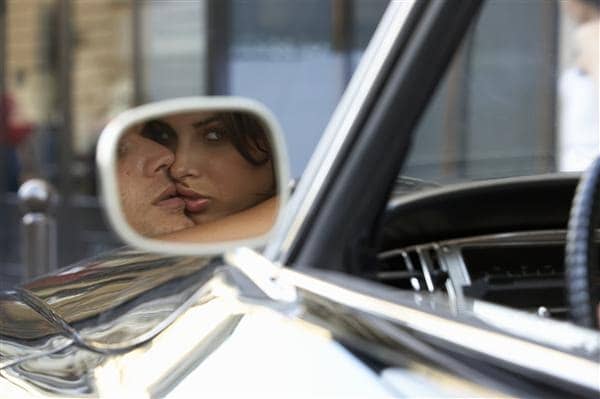 Couple Embracing in Car Reflected in Wing Mirror